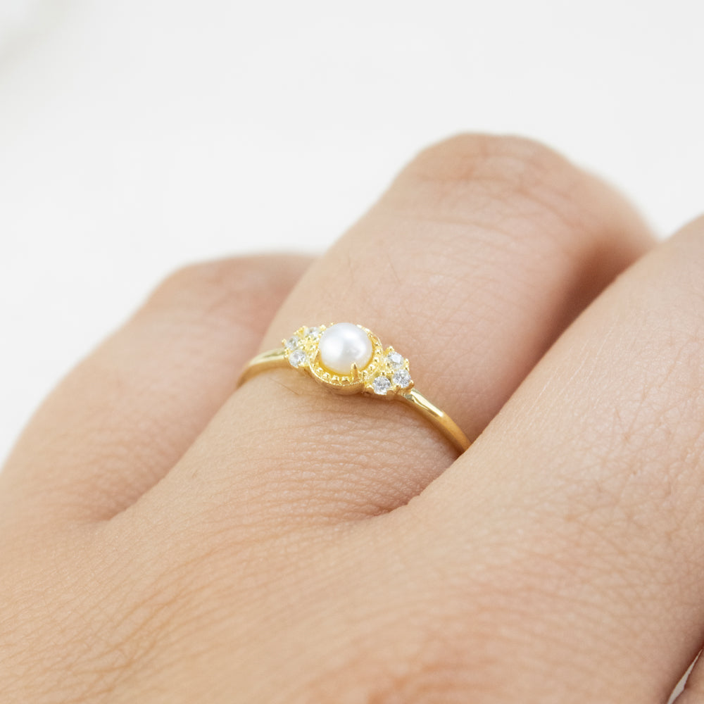 Anillo delicado con perla y piedras pequeñas. Anillo dorado