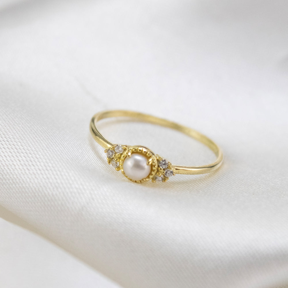 Anillo delicado con perla y piedras pequeñas. Anillo dorado