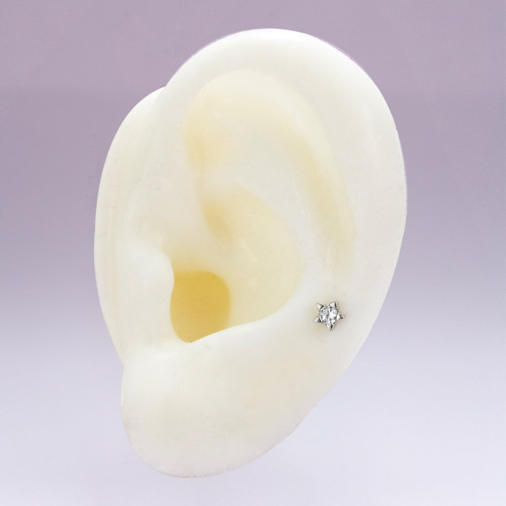 Piercing en forma de estrella plateada con piedra al centro 