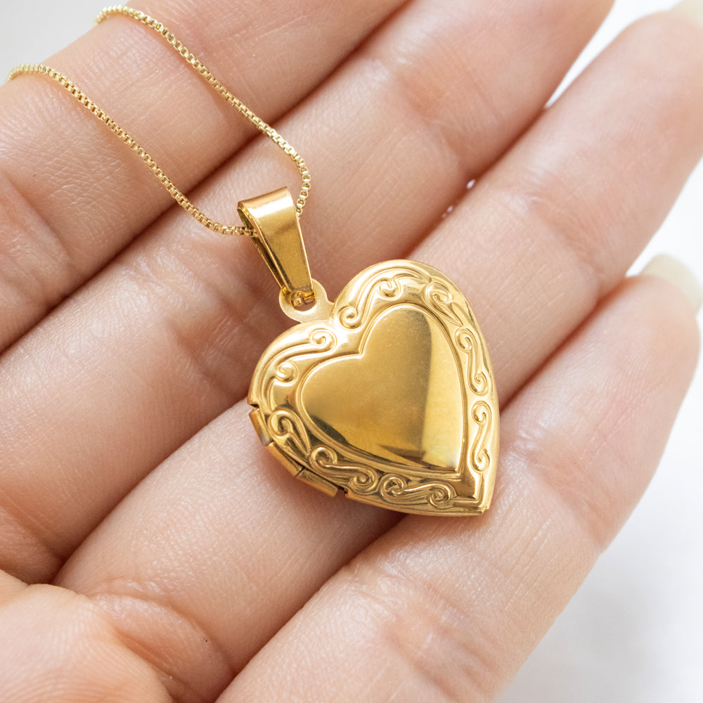 Collar relicario en forma de corazón con grabado, para colocar fotos dentro de el. Collar en tono dorado/acero