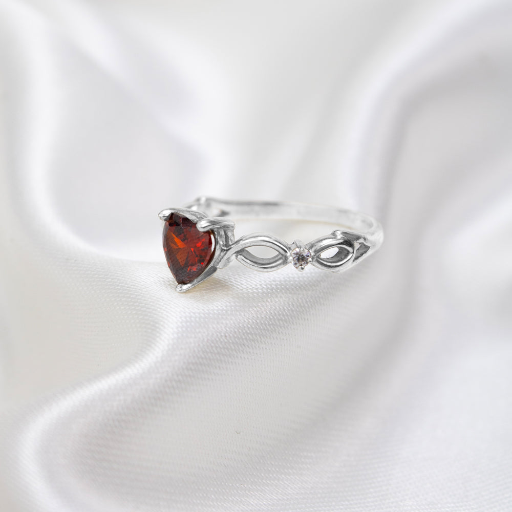 Anillo plateado con corazón rojo y diseño