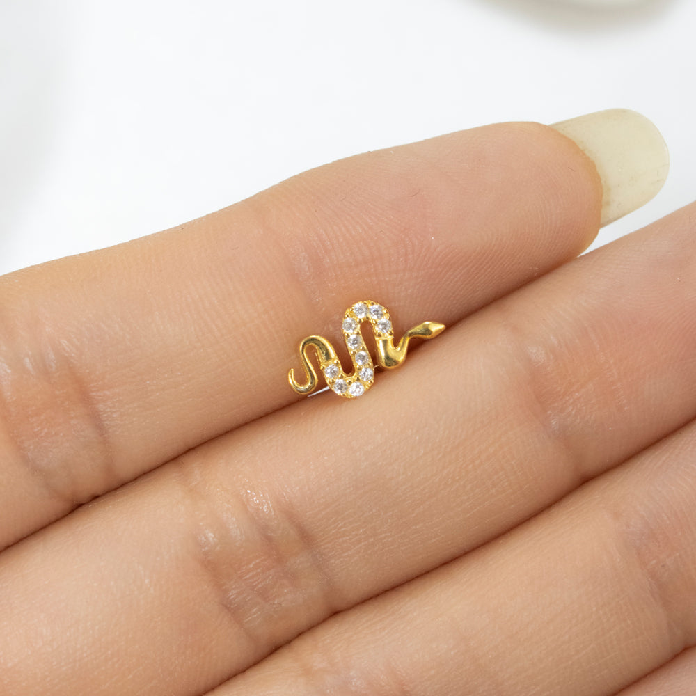 Piercing en forma de serpiente dorada con piedras en el centro